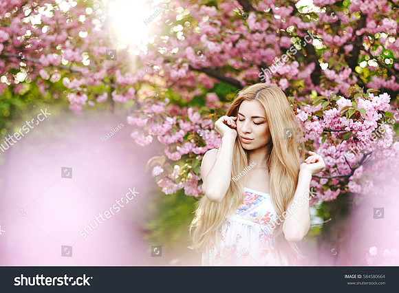 stock-photo-spring-portraits-gorgeous-young-woman-on-cherry-blossom-background-584580664